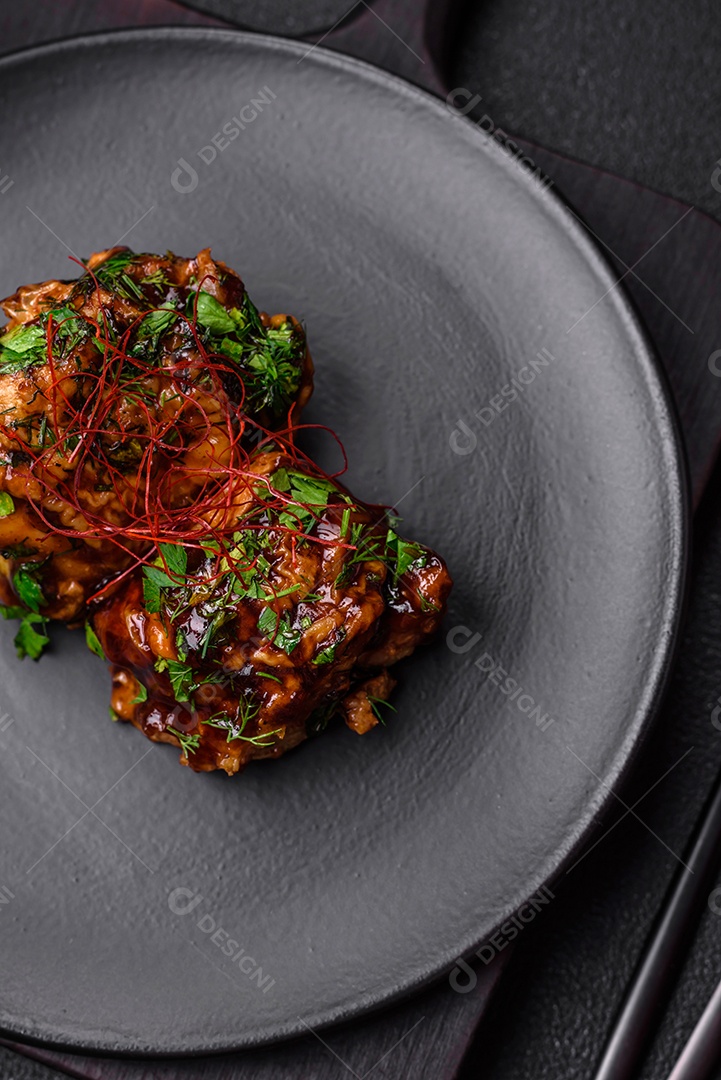 Delicioso frango frito suculento em molho teriyaki com sal, especiarias, ervas e sementes de gergelim num prato cerâmic