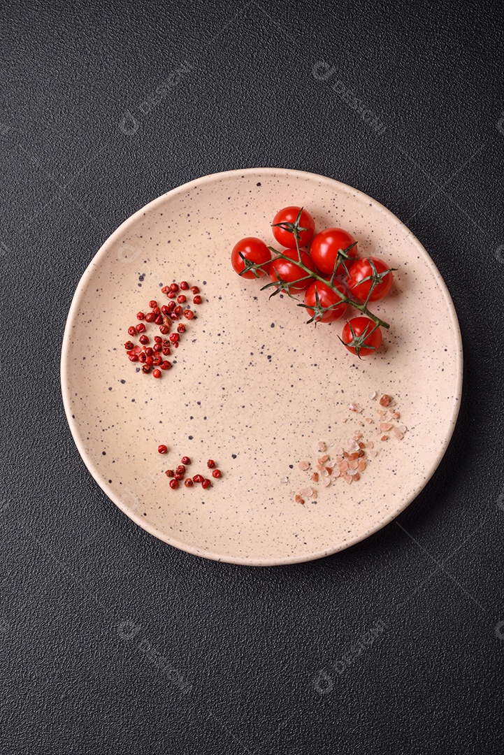 Prato cerâmico vazio em um fundo escuro texturizado. Preparando utensílios de cozinha para um jantar em família
