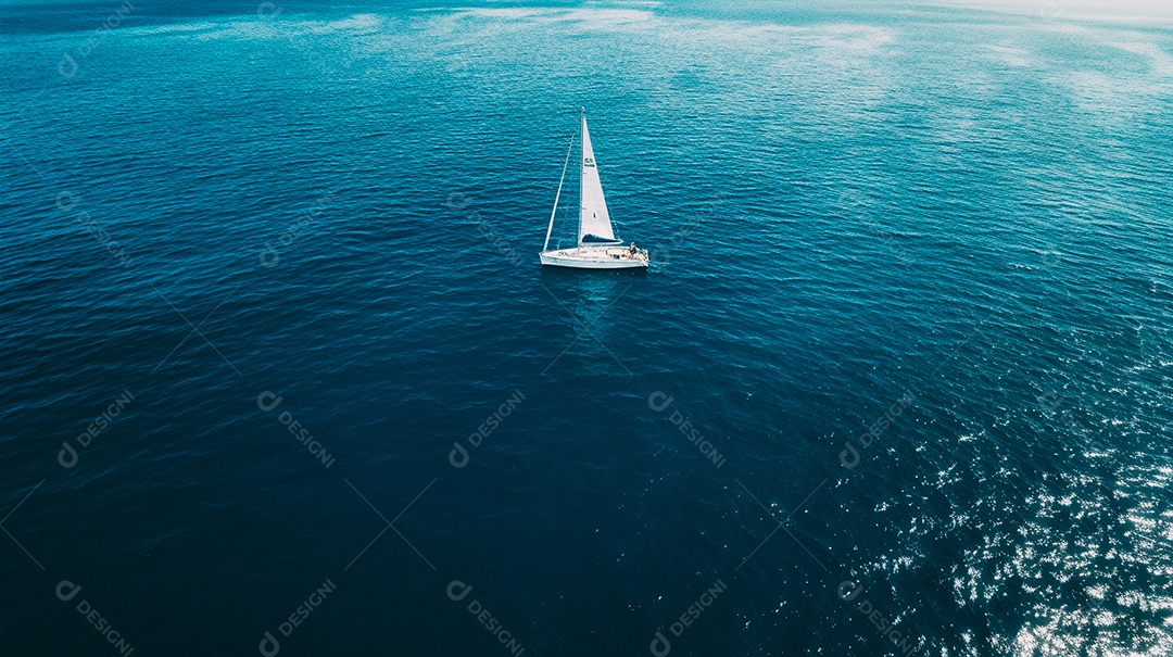 Foto aérea de um veleiro isolado no meio do oceano