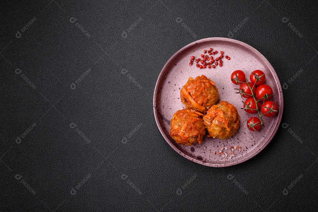 Deliciosas almôndegas frescas de carne picada ou peixe com molho de tomate, cenoura, cebola, sal e especiarias sobre um fundo escuro de concreto