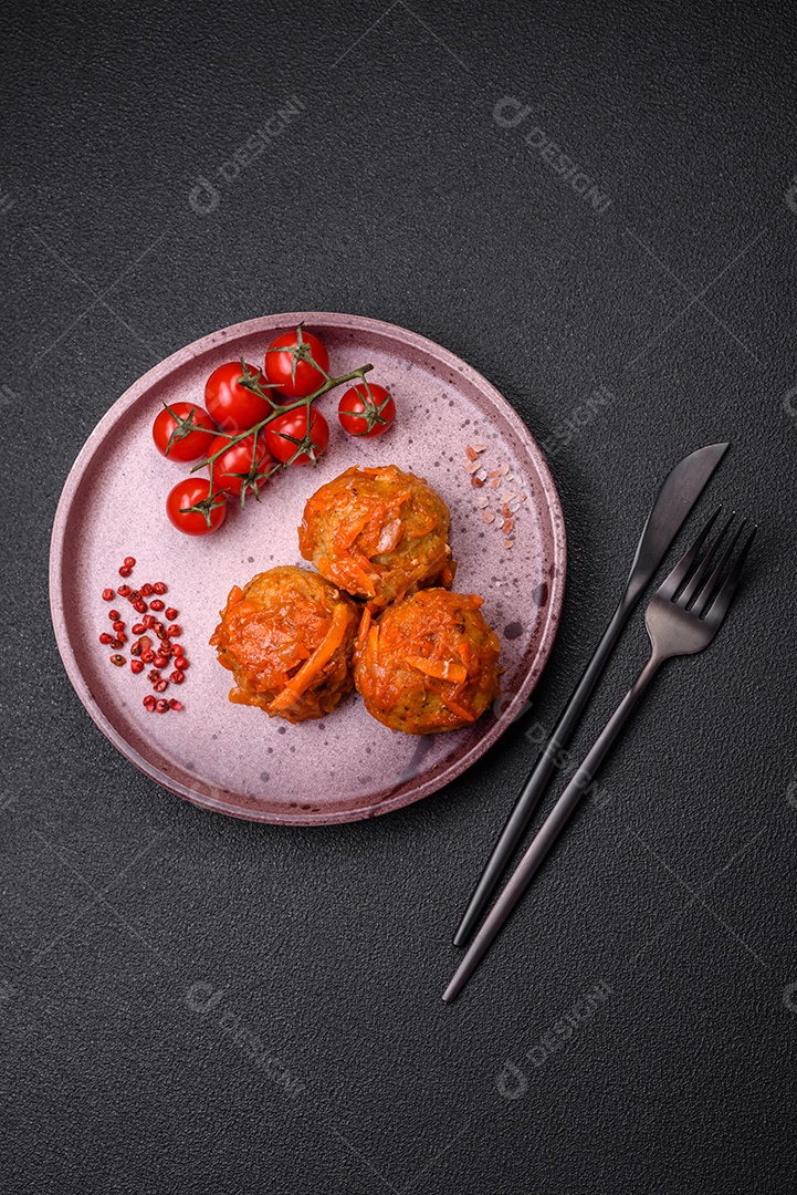 Deliciosas almôndegas frescas de carne picada ou peixe com molho de tomate, cenoura, cebola, sal e especiarias sobre um fundo escuro de concreto