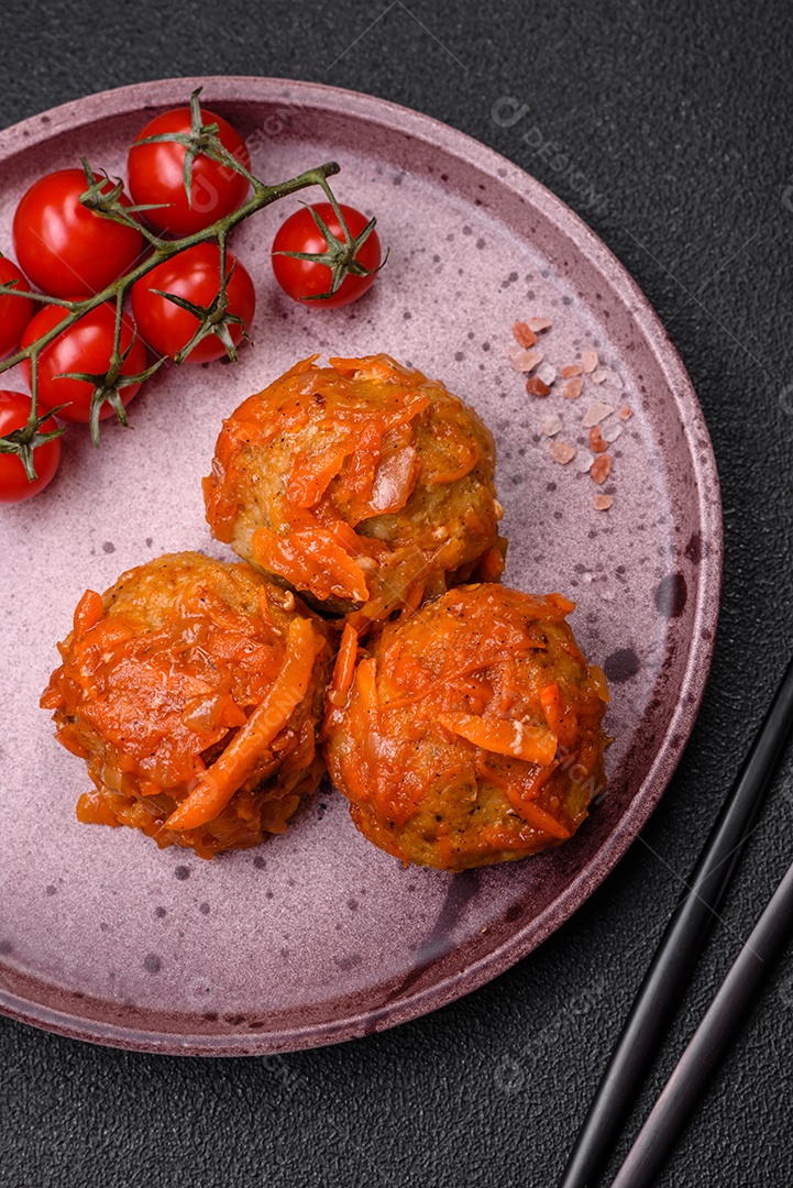 Deliciosas almôndegas frescas de carne picada ou peixe com molho de tomate, cenoura, cebola, sal e especiarias sobre um fundo escuro de concreto