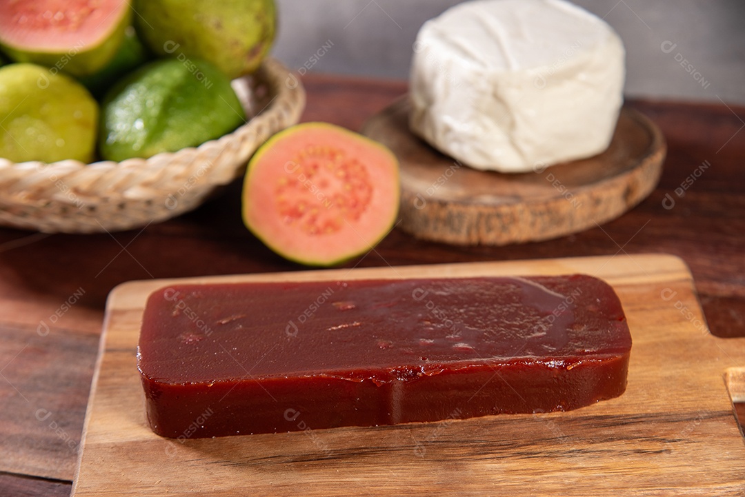 Doce de goiaba com frutas em uma tigela e queijo sobre tábua de madeira