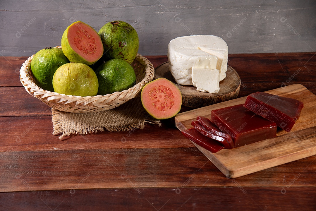 Doce de goiaba com frutas em uma tigela e queijo sobre tábua de madeira