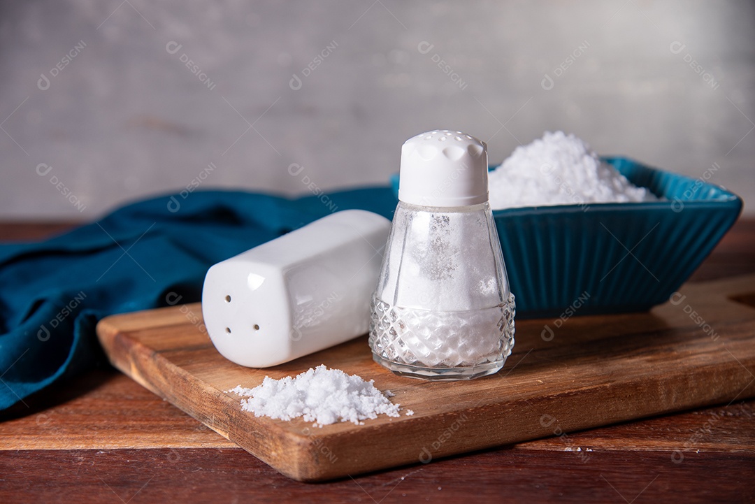 Saleiros de vidro sobre uma tábua de madeira