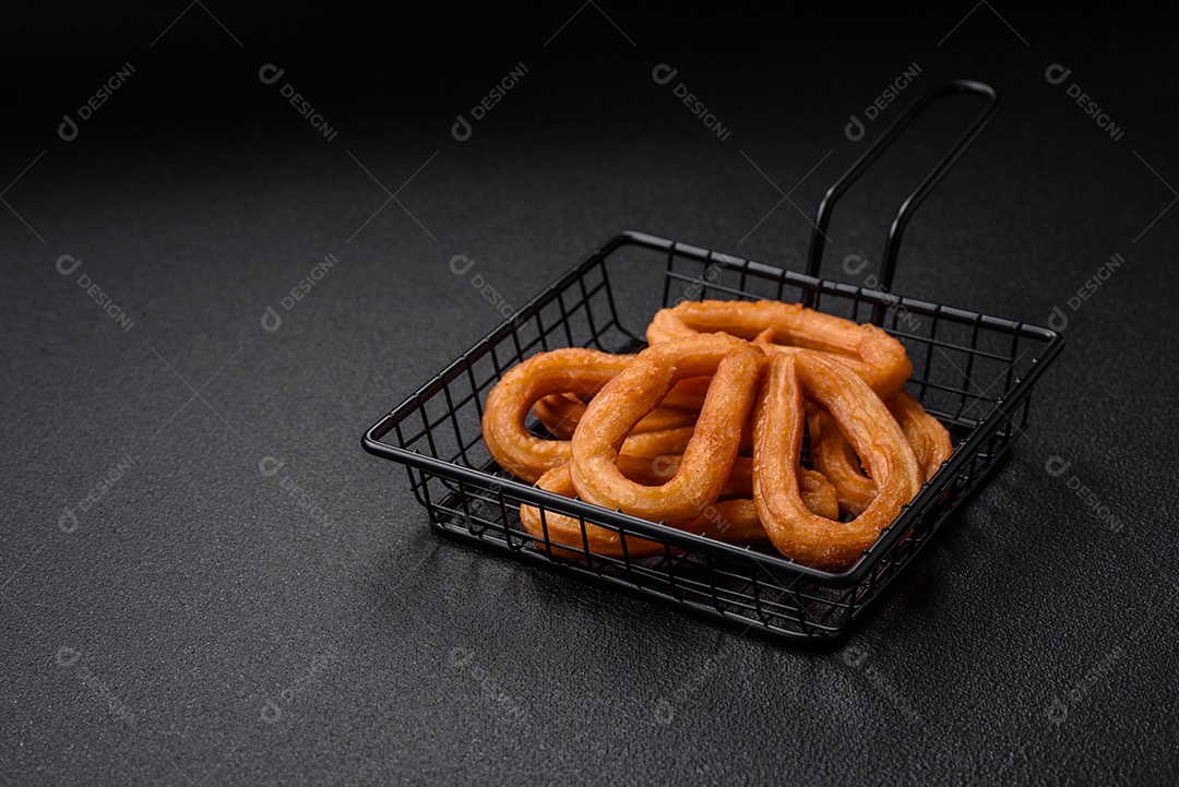 Deliciosos churos doces com açúcar de confeiteiro e creme dentro sobre um fundo escuro de concreto. Prato de fast-food