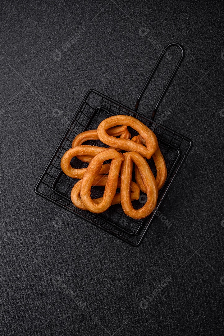 Deliciosos churos doces com açúcar de confeiteiro e creme dentro sobre um fundo escuro de concreto. Prato de fast-food