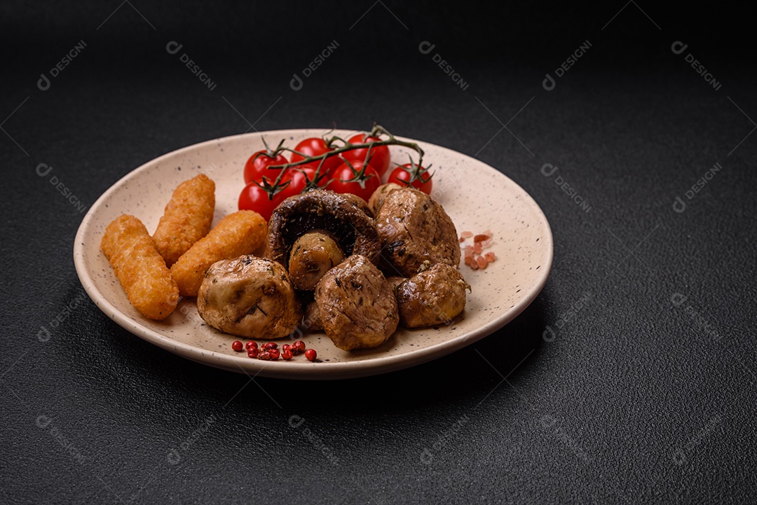 Deliciosos champignon inteiros e suculentos assados ​​na grelha com sal e especiarias em uma placa de cerâmica sobre um fundo escuro de concreto