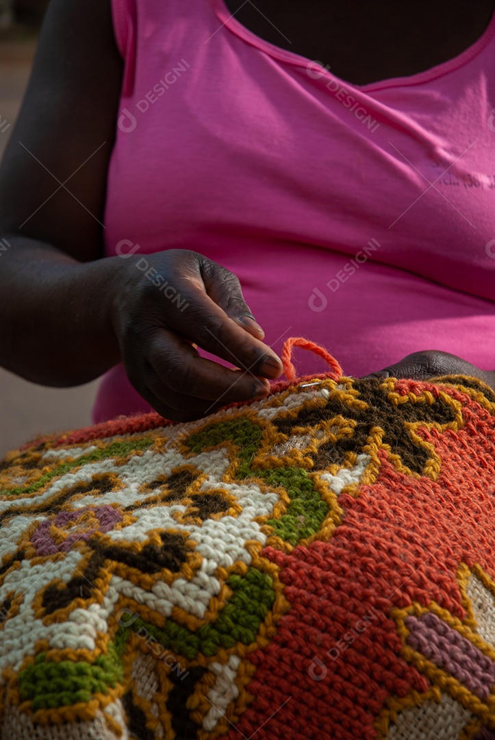 Mulher negra fazendo crochê