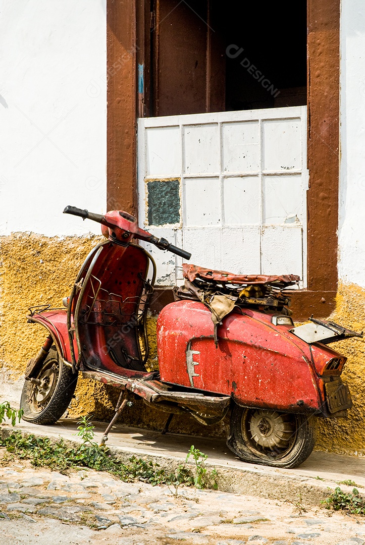 Moto antiga sobre fachada de uma casa