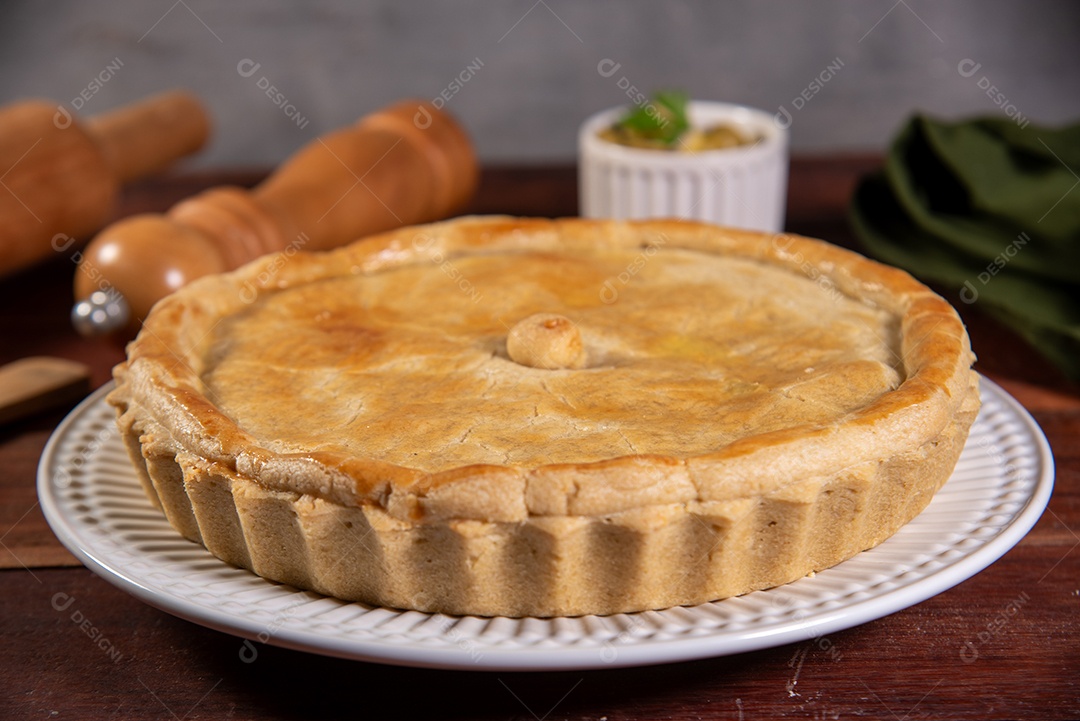 Empadão de frango sobre uma mesa de madeira