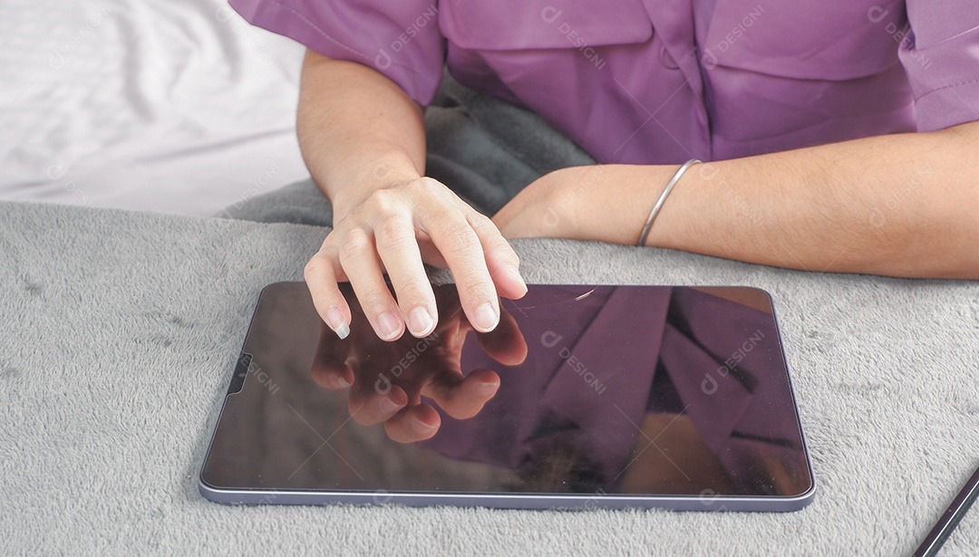 Mulher acessando tablet em uma mesa de mármore