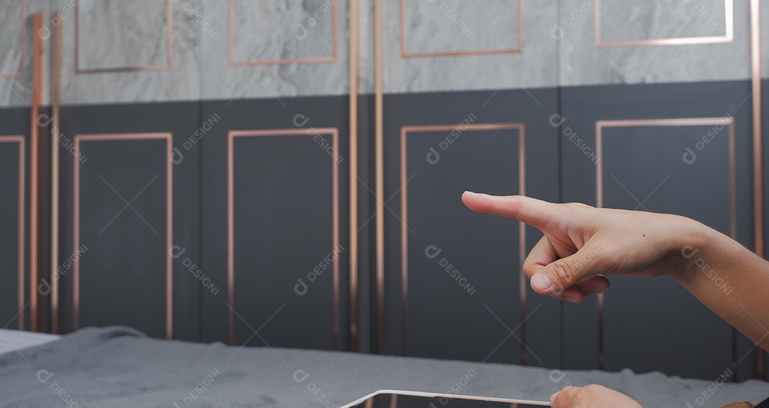 Mão segurando tablet e apontando