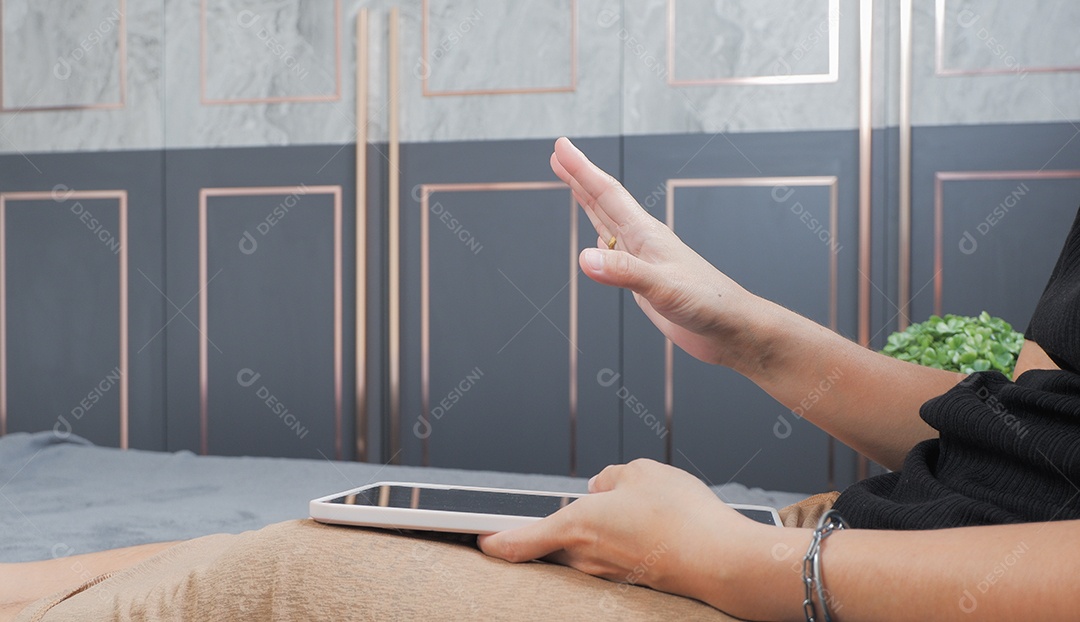 Mão de uma mulher operando um tablet