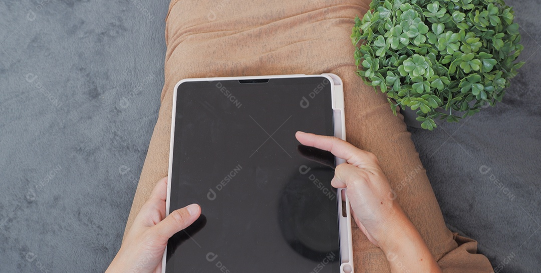 Mão de uma mulher operando um tablet