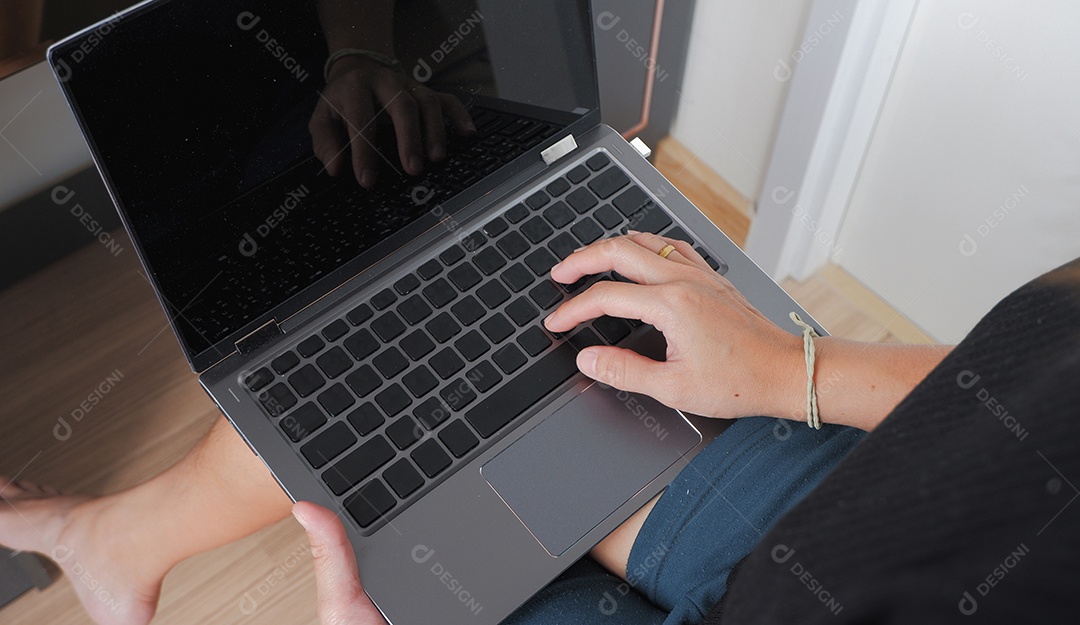 Mulher com notebook no colo mexendo