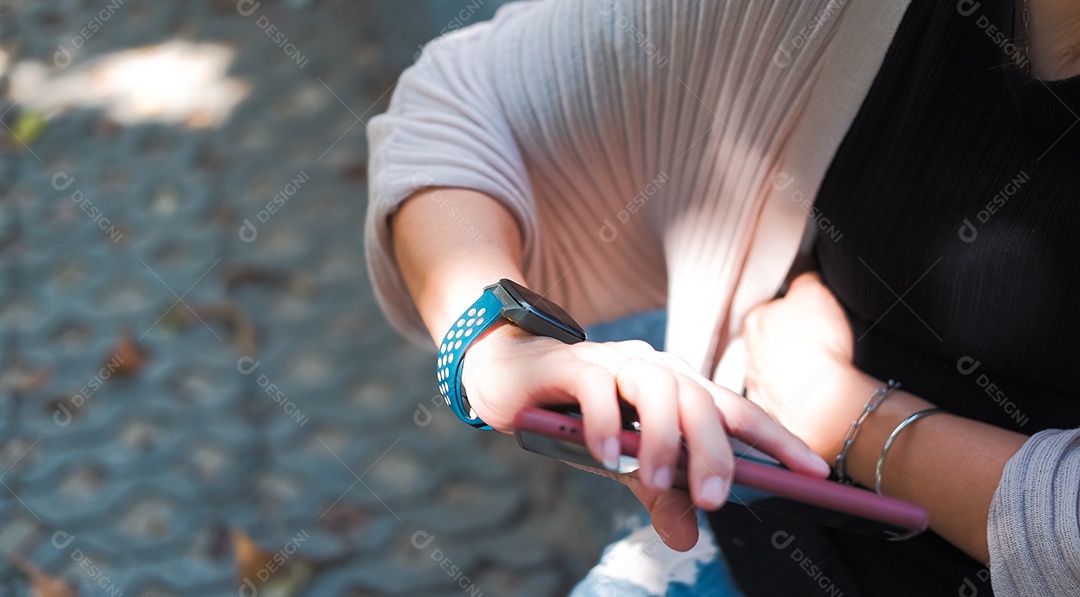 Mulher olhando horas no relógio com celular na mão