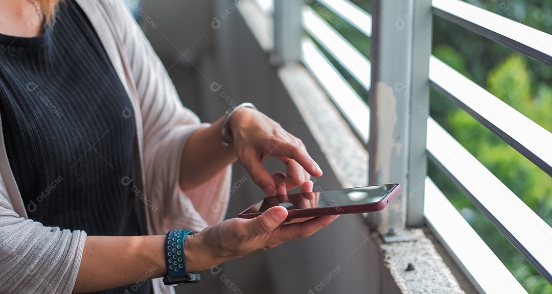 Uma mulher mexendo no celular em uma area de laser