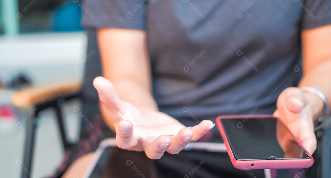 Uma mulher segurando celular e fazendo gesto