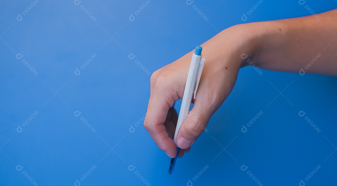 Mão feminina segurando uma caneta para escrever