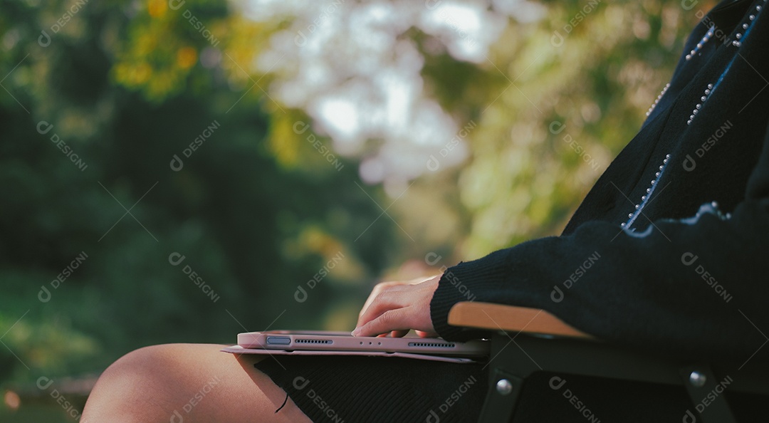 Mulher relaxando com laptop no jardim