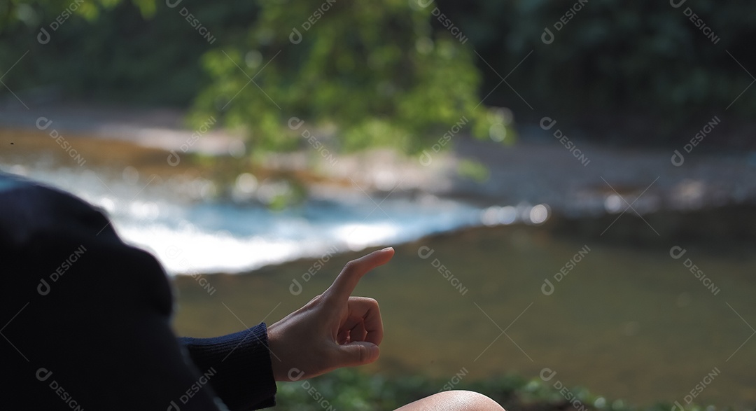 Mulher em jardim apontando para algo