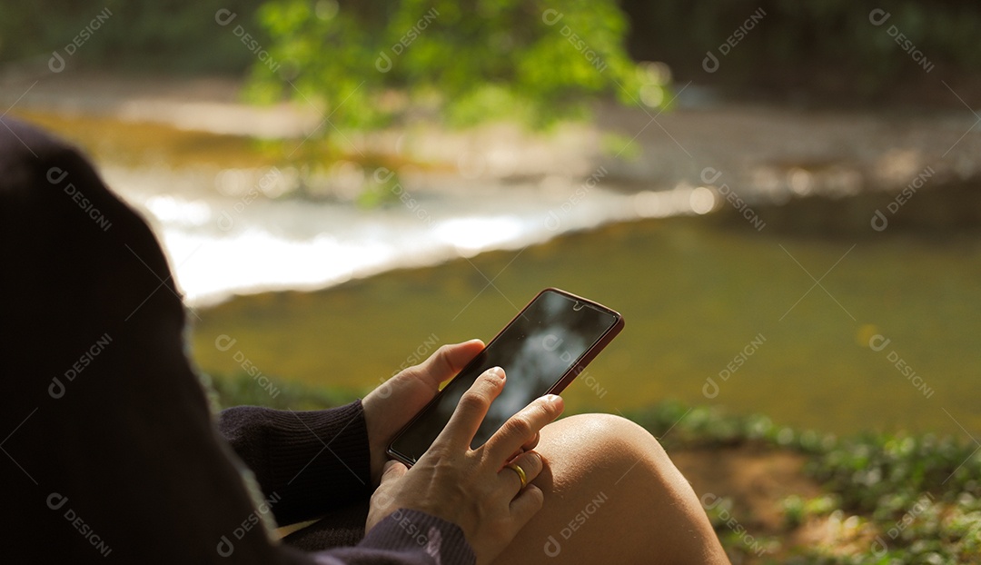 Mulher relaxando com telefone celular no jardim