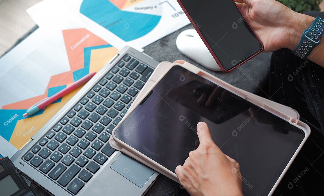 Mesa de trabalho sobre análise de dados e mãos trabalhando em laptop móvel