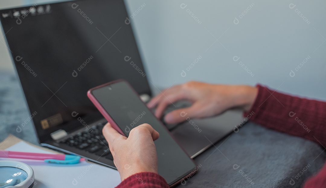 Uma mulher com notebook e celular para trabalho