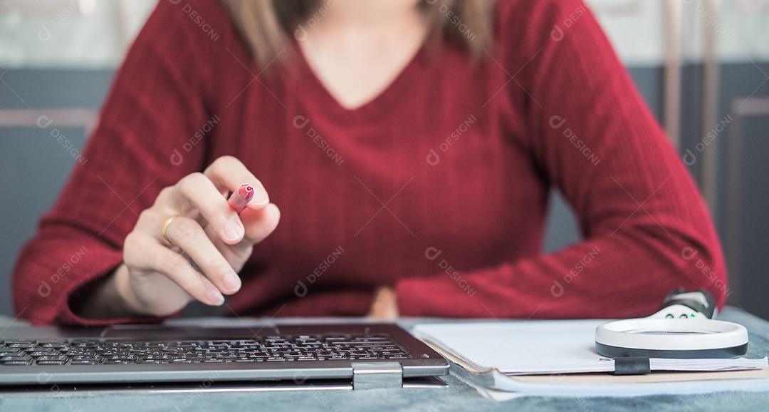 Mulher trabalhando usando notebook e caneta
