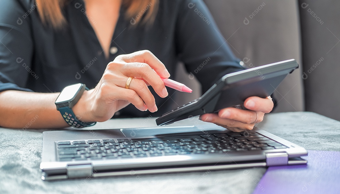 Mulher usando notebook para analisar dados fazendo conta na calculadora