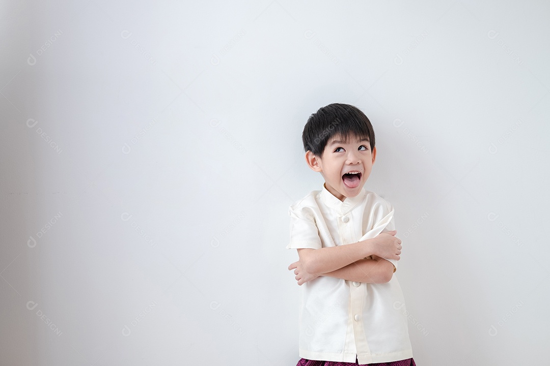 Menino asiático fazendo careta de braços cruzados