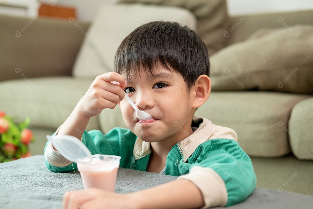 Um lindo garotinho comendo seu iogurte