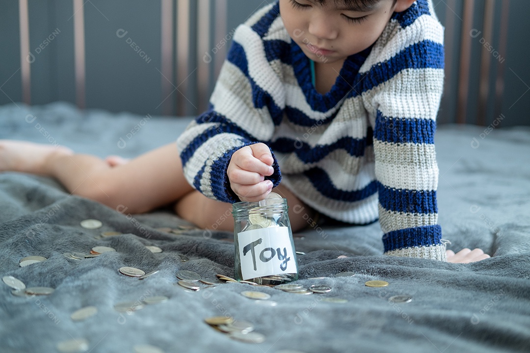 Menino colocando dinheiro dentro do vidro