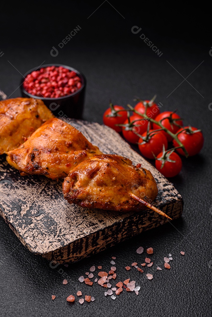 Delicioso kebab de frango fresco com sal, especiarias e ervas sobre um fundo escuro de concreto