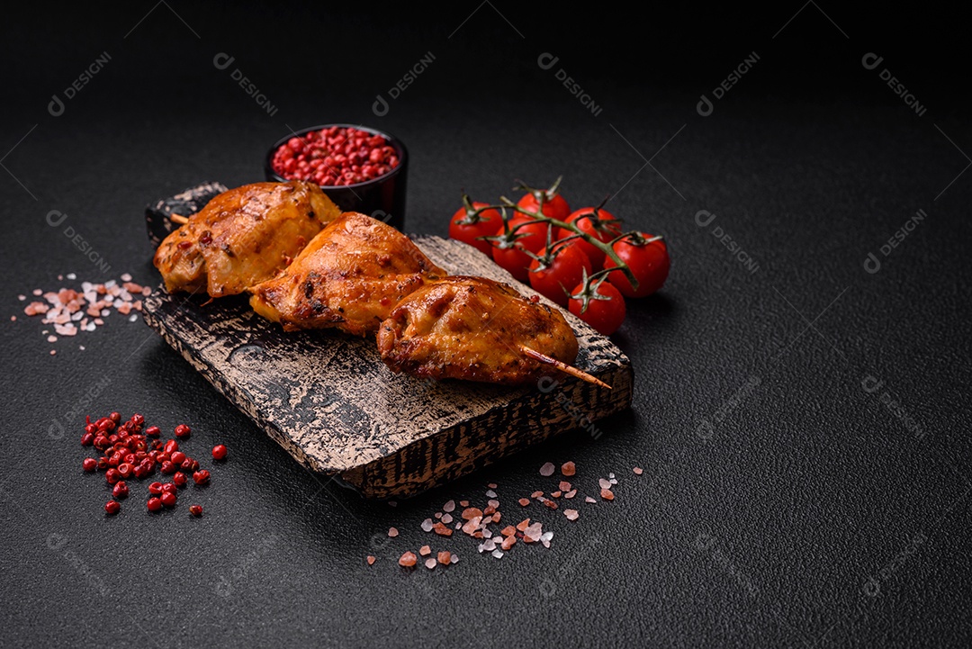 Delicioso kebab de frango fresco com sal, especiarias e ervas sobre um fundo escuro de concreto