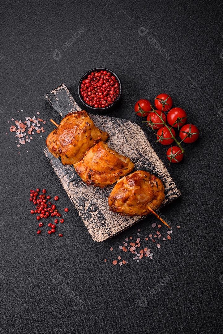 Delicioso kebab de frango fresco com sal, especiarias e ervas sobre um fundo escuro de concreto