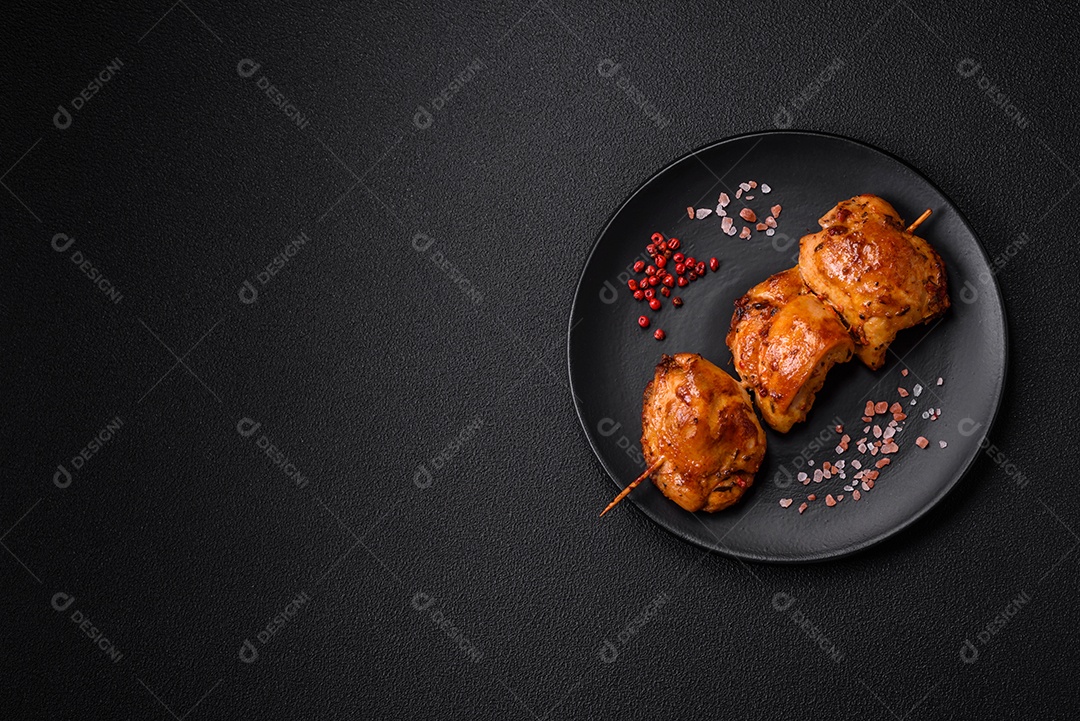 Delicioso kebab de frango fresco com sal, especiarias e ervas sobre um fundo escuro de concreto