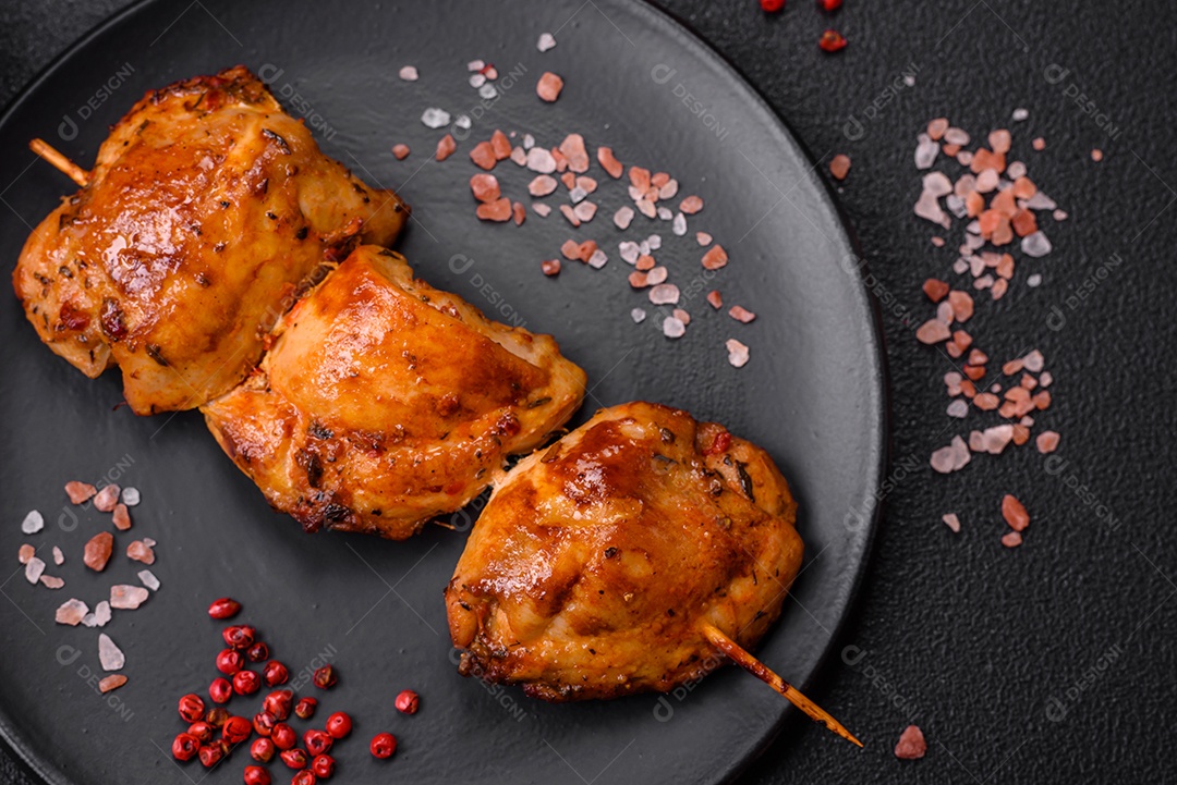 Delicioso kebab de frango fresco com sal, especiarias e ervas sobre um fundo escuro de concreto