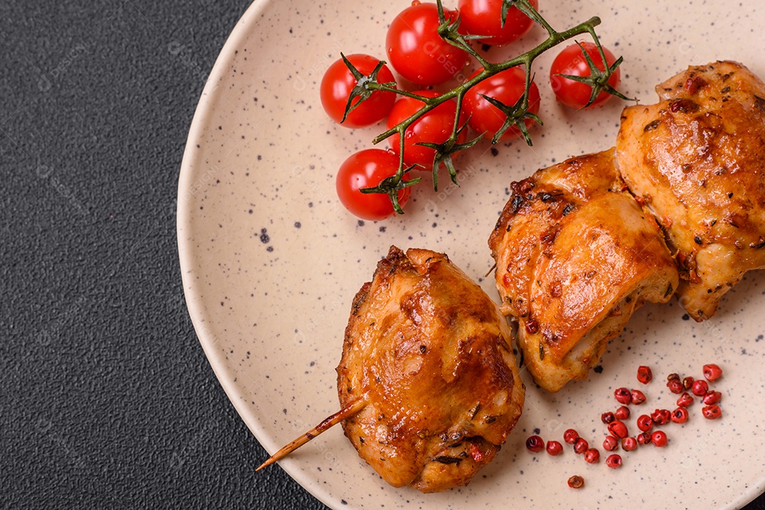 Delicioso kebab de frango fresco com sal, especiarias e ervas sobre um fundo escuro de concreto