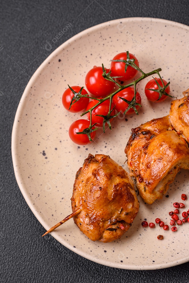 Delicioso kebab de frango fresco com sal, especiarias e ervas sobre um fundo escuro de concreto