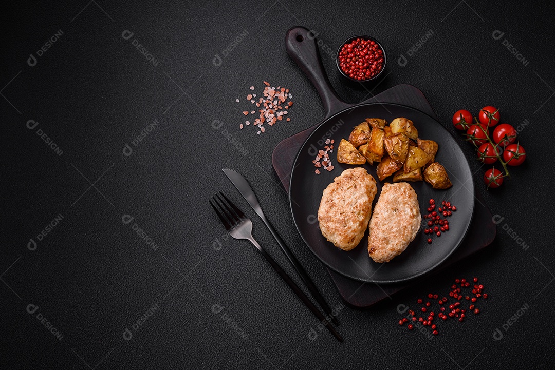 Deliciosas costeletas de frango fresco ou almôndegas com sal, especiarias e ervas sobre um fundo escuro de concreto