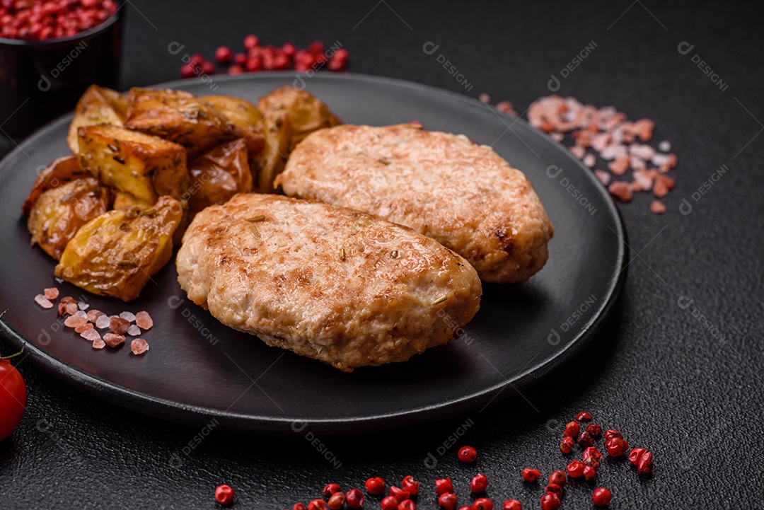 Deliciosas costeletas de frango fresco ou almôndegas com sal, especiarias e ervas sobre um fundo escuro de concreto