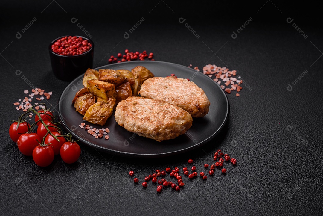 Deliciosas costeletas de frango fresco ou almôndegas com sal, especiarias e ervas sobre um fundo escuro de concreto