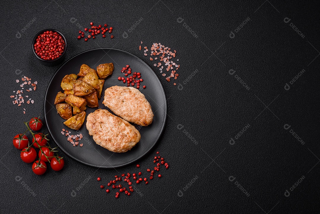 Deliciosas costeletas de frango fresco ou almôndegas com sal, especiarias e ervas sobre um fundo escuro de concreto