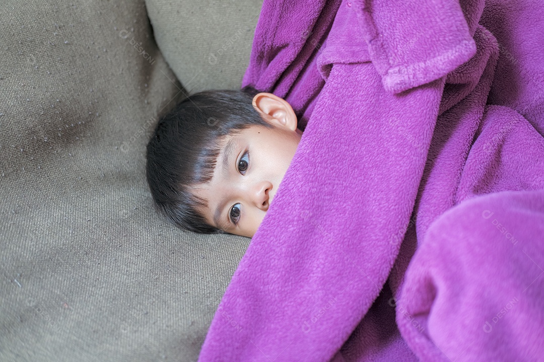 Pequeno garoto asiático deitado doente