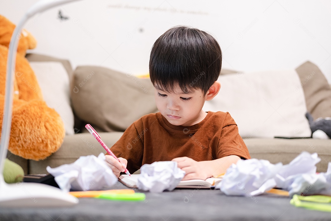 Menino asiático desenhando na mesa