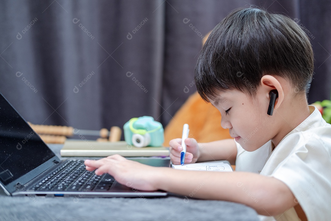 Menino asiático estudando em notebook