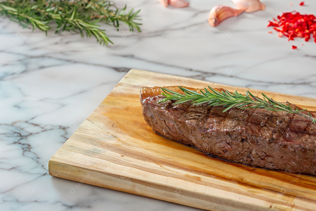 Picanha sobre fundo mármore com alecrim, alho e pimenta