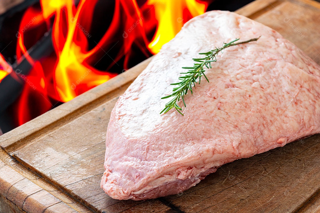 Picanha crua ou lombo de cima em uma tábua com fundo de fogo